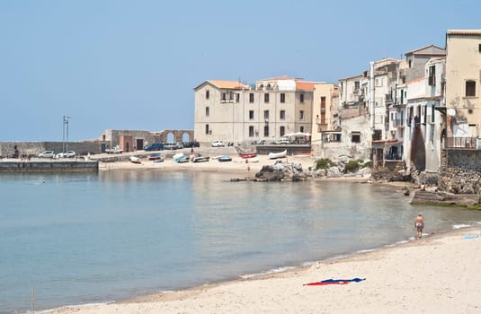 Cefalu Beach with old buildings and clear  blue sky. Sicily