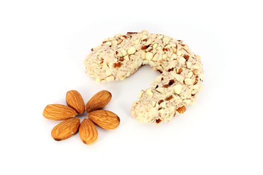 Homemade cake in shape of crescent with some almonds, isolated on white