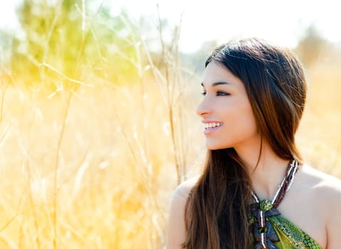 Asian indian woman profile portrait in golden grass field