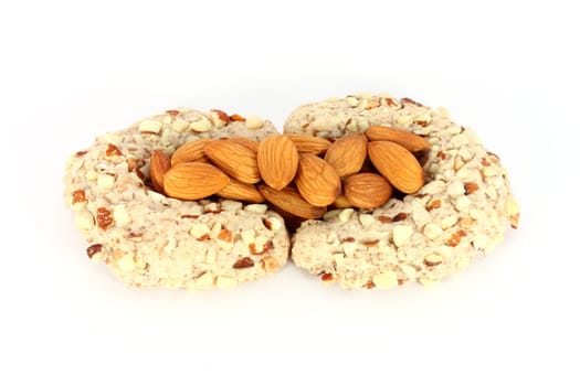 Homemade cakes in shape of crescent with some almonds, isolated on white