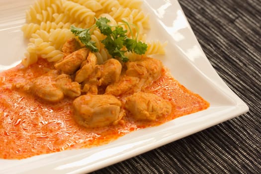 Chicken pieces with Pasta in Paprika Cream Sauce. Decorated with parsley.