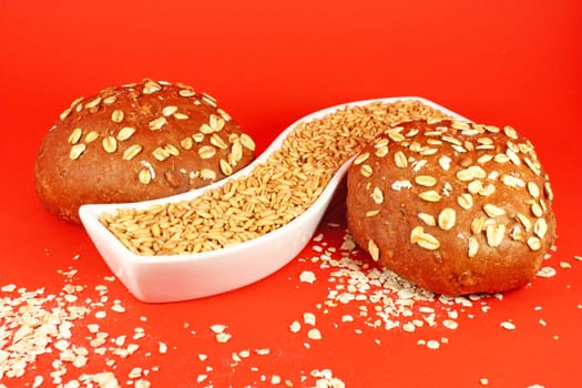 Two pastries with oat seeds on red background