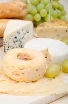 Various Types of Cheese and Grapes on Wooden Chopping Board