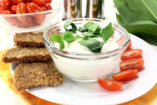 a bowl of wild garlic quark with bread and tomatoes