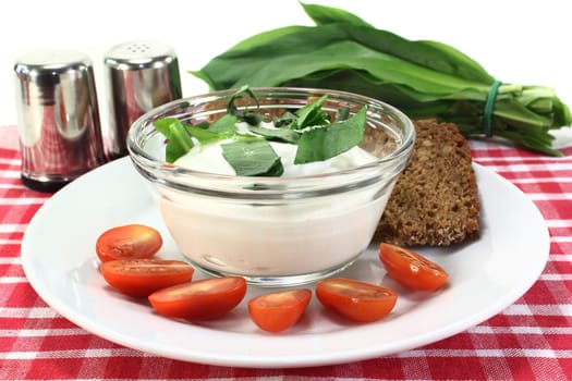 a bowl of wild garlic quark with bread and tomatoes