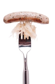 On a fork a Nuremberg bratwurst and sauerkraut