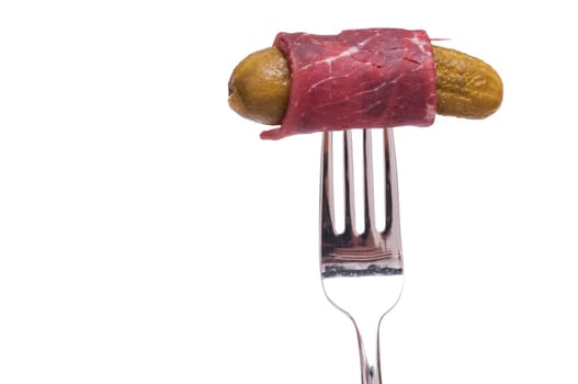 Raw beef ham with cucumber on a fork white cut out