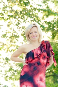 smiling woman in outdoors with green leaves in the background