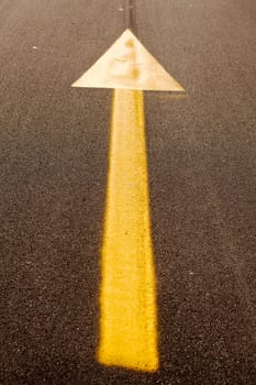 Yellow arrow on new asphalt