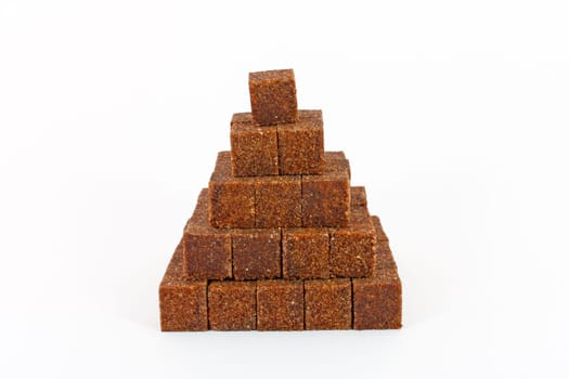 Pyramid made of cane sugar cubes isolated on white