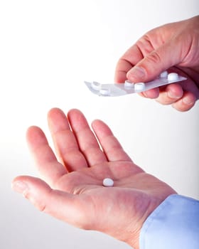 Hand giving pills isolated on white background