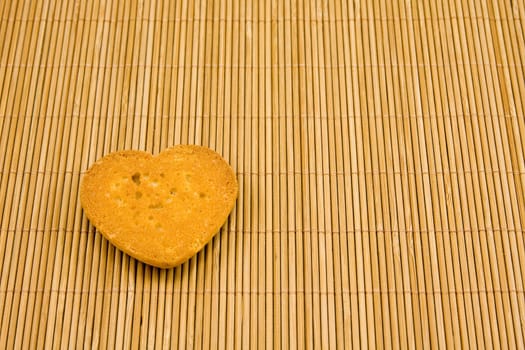 heart shaped cookie on striped bamboo tablecloth