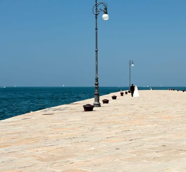 Spouses walking on molo Audace in Trieste