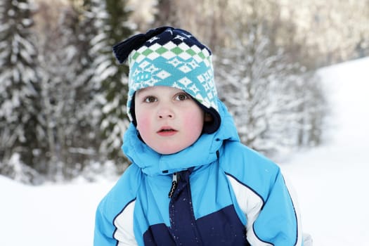Portrait small boy in winter on mountains