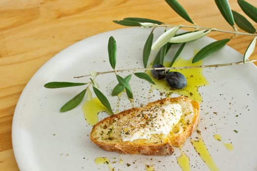 Bread, ricotta, oil and olive oil on dish