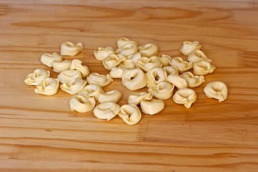 Tortellini, Italian pasta on wooden surface