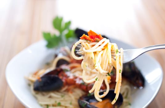 Spaghetti with mussels on wooden table