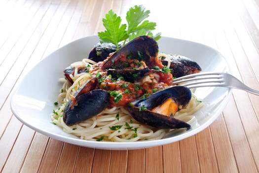 Spaghetti with mussels on wooden table