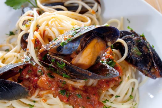 Spaghetti with mussels on wooden table