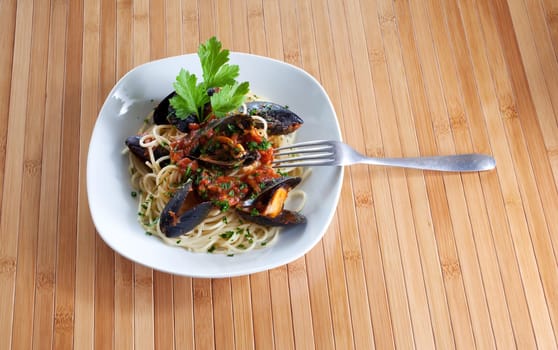 Spaghetti with mussels on wooden table