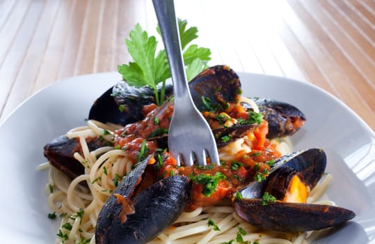 Spaghetti with mussels on wooden table