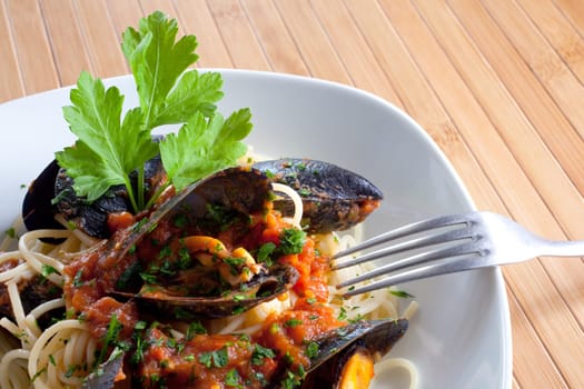 Spaghetti with mussels on wooden table