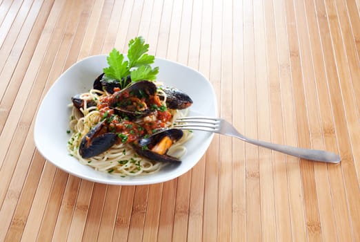 Spaghetti with mussels on wooden table
