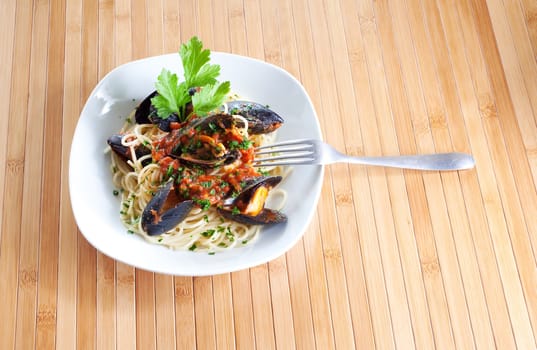 Spaghetti with mussels on wooden table