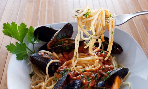 Spaghetti with mussels on wooden table