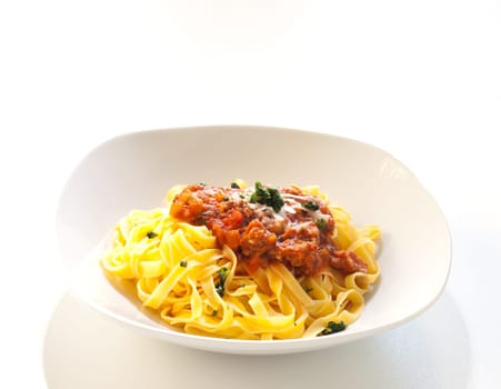 Italian pasta with ragout sauce on white background