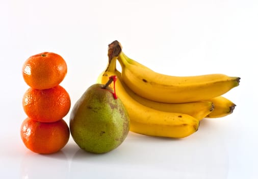 Decana pear, tangerines and bananas on white background
