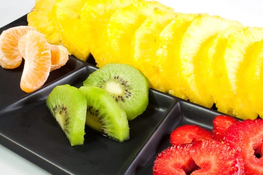 Sliced fruits on black saucer