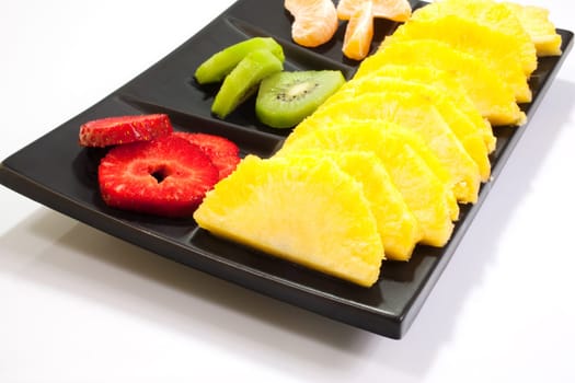 Sliced fruits on black saucer