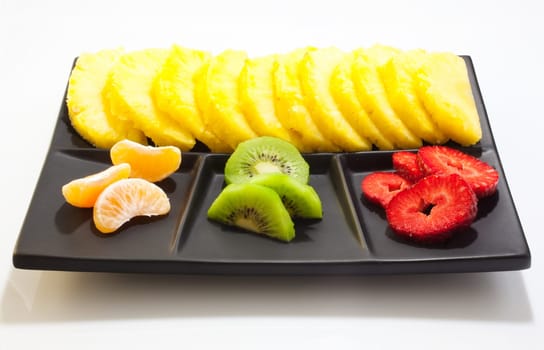 Sliced fruits on black saucer