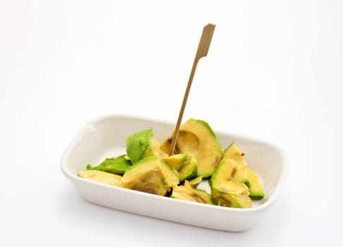 Avocado inside a saucer on white background