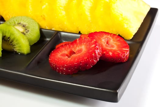 Sliced fruits on black saucer