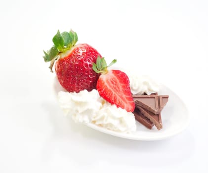 Strawberries cream and chocolate on saucer
