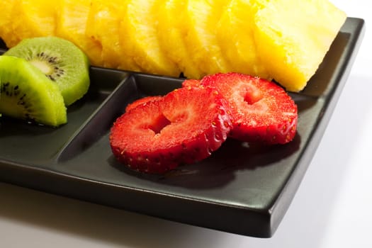Sliced fruits on black saucer