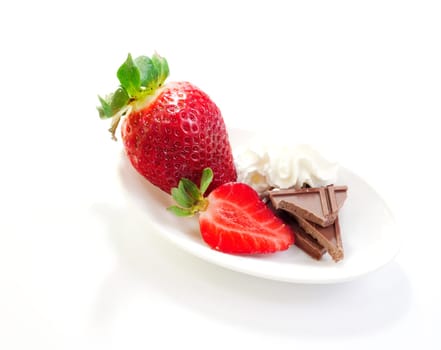 Strawberries cream and chocolate on saucer