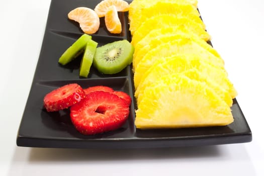 Sliced fruits on black saucer