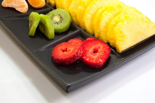 Sliced fruits on black saucer