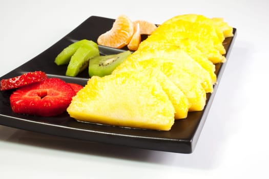 Sliced fruits on black saucer