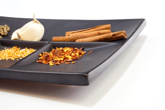 Different Spices on a black saucer