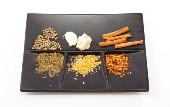 Different Spices on a black saucer