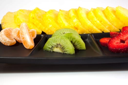 Sliced fruits on black saucer