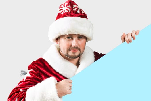 Male caucasian model of santa claus holding a blue board