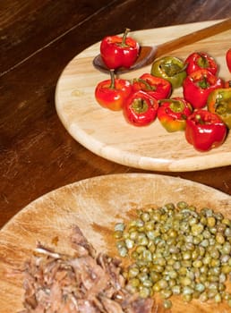 Red hot chili peppers on cutting board, capers and anchovies