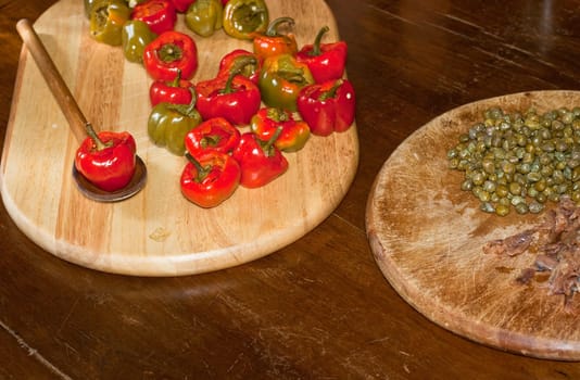 Red hot chili peppers on cutting board, capers and anchovies