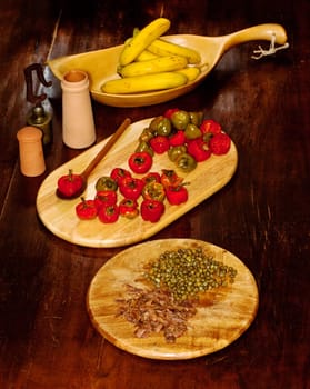 Red hot chili peppers on cutting board, bananas, capers and anchovies