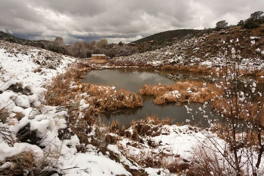 Landscape in the desert with snow and a reservoir